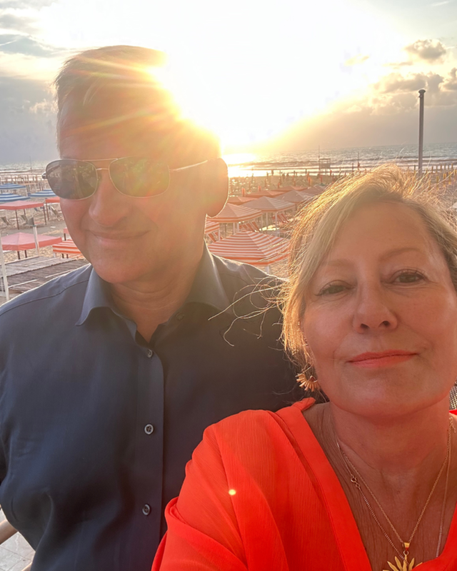 Carole Ann Rice with her husband Patrick, smiling together at sunset on a beach